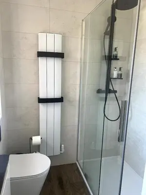 a bathroom with a toilet and a glass shower at Home2Home Meadow Close in East Kilbride
