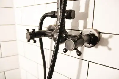 a shower head is attached to a white tile wall at Boutique Bothy - Unique Bolthole in the New Town in Edinburgh