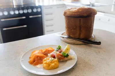a plate of food on a counter with a piece of bread at Kilmeny in Ballygrant