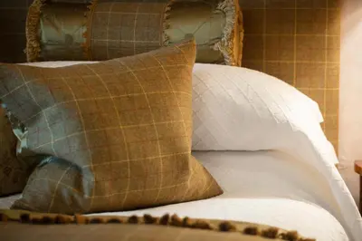 a bed with two pillows and a brown and white pillow at Kilmeny in Ballygrant