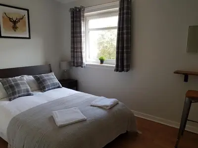 a bedroom with a bed with two towels on it at The Abercromby Townhouse - Close to Merchant City in Glasgow
