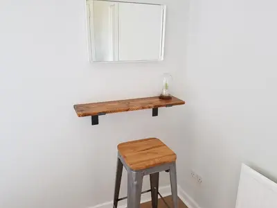 a wooden stool and a mirror on a wall at The Abercromby Townhouse - Close to Merchant City in Glasgow