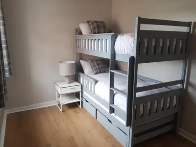 a bedroom with two bunk beds and a lamp at The Abercromby Townhouse - Close to Merchant City in Glasgow