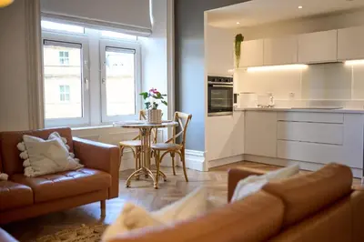 a kitchen and living room with a couch and a table at Exceptional Central 1BR Apt - town square views in Oban