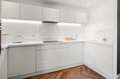 a white kitchen with white cabinets and a sink at Exceptional Central 1BR Apt - town square views in Oban