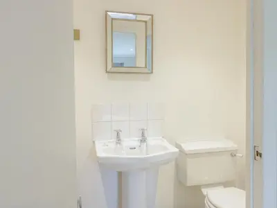 a white bathroom with a sink and a toilet at Gate Lodge in West Calder
