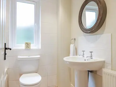 a bathroom with a toilet and a sink and a mirror at Gate Lodge in West Calder