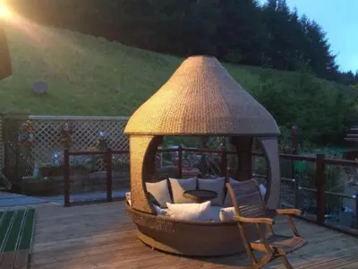a gazebo sitting on a deck with two chairs at Ramintoul Lodge in Glendevon