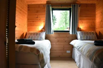 two beds in a log cabin with a window at Lodge at Loch Lomond in Glasgow