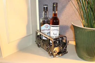two bottles of wine in a metal holder next to a plant at The Victoria Inn Blythswood Snug in Falkirk