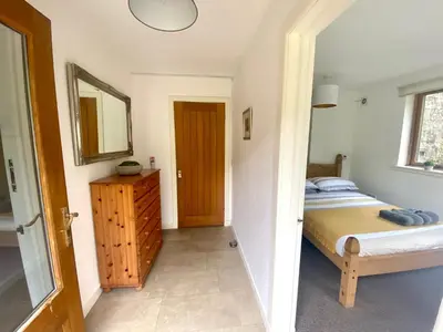 a small bedroom with a bed and a mirror at Inversnaid Bunkhouse in Inversnaid