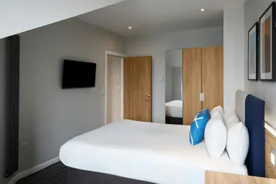 a bedroom with a white bed with pillows at Four Points Flex by Sheraton Edinburgh in Edinburgh
