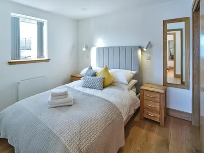 a bedroom with a large bed and a mirror at White Watch in Lochaline