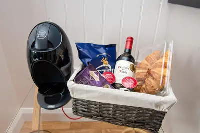 a basket filled with wine and bread and a blender at Super King Lodge-Sleeps 2-HotTub-Sea View in Langbank