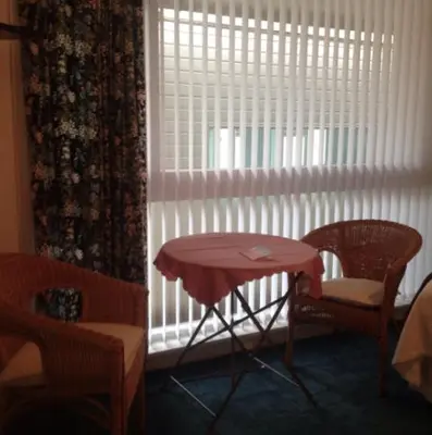 a table and chairs in a room with a window at The Clan MacGregor Room in Kilmarnock