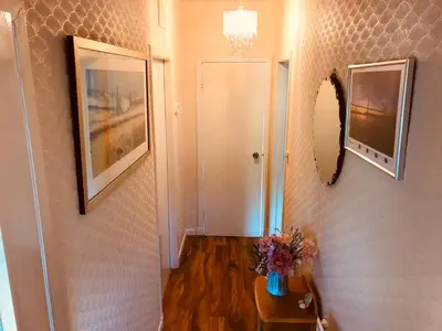 a hallway with a table with flowers and a mirror at Anna apartment in Edinburgh