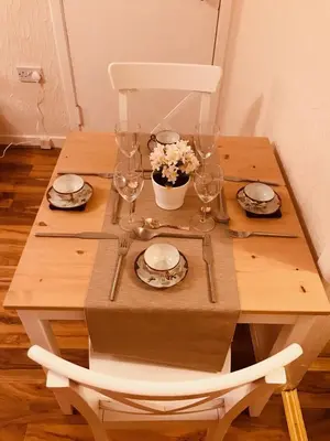 a wooden table with plates and wine glasses on it at Anna apartment in Edinburgh