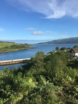 a bridge over a river next to a body of water at Red Watch Apartment in Oban