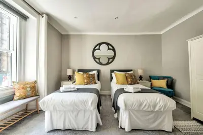 a bedroom with two beds with pillows and a mirror at GuestReady - Spacious and Beautiful 2BR Flat in Morningside in Edinburgh