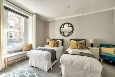 a bedroom with two beds and a window at GuestReady - Spacious and Beautiful 2BR Flat in Morningside in Edinburgh