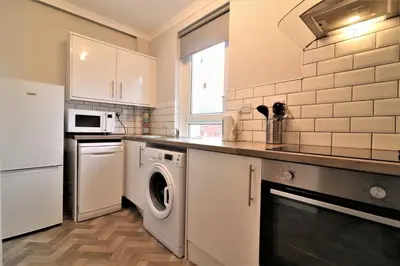 a kitchen with a washer and dryer in it at Signature - Bruce Terrace Lower in High Blantyre