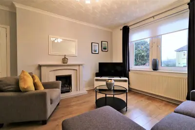 a living room with a couch and a fireplace at Signature - Bruce Terrace Lower in High Blantyre