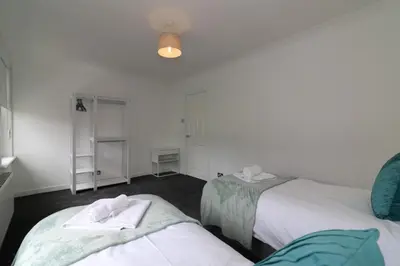 a bedroom with two beds with towels on them at Signature - New View Place in Bellshill