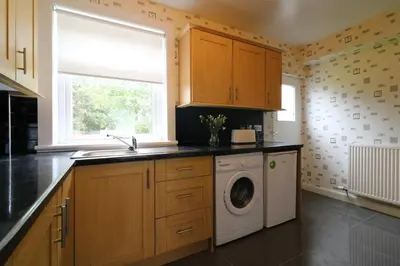 a kitchen with a washing machine and a window at Signature - New View Place in Bellshill