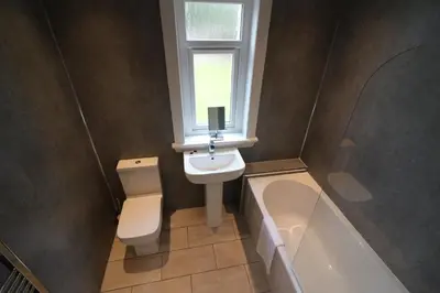 a bathroom with a toilet and a sink and a window at Signature - New View Place in Bellshill