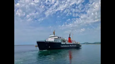 a large ship in the water under a cloudy sky at Arran Ferry Apartment in Ardrossan