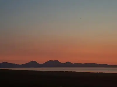 a sunset over the water with mountains in the background at Haagwood Cottage in Cretshengan