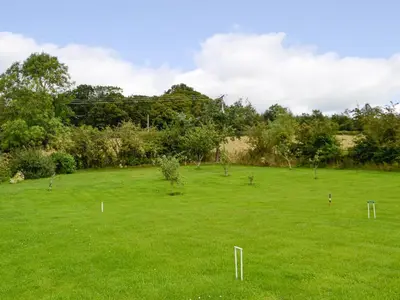 a large green field with trees in it at The Brewers Cottage in Mauchline