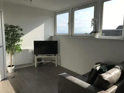 a living room with a couch and a flat screen tv at Carvetii - Edward House C - 2 Dbl bed 2nd floor flat in Dunfermline