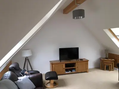 a living room with a couch and a flat screen tv at Hawthorn Cottage in Glencoe