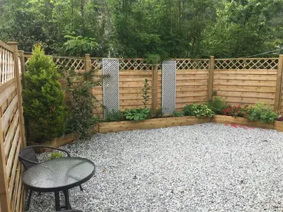 a garden with a fence and a table and a chair at Hawthorn Cottage in Glencoe