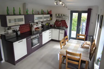 a kitchen with a table and a dining room at Hawthorn Cottage in Glencoe