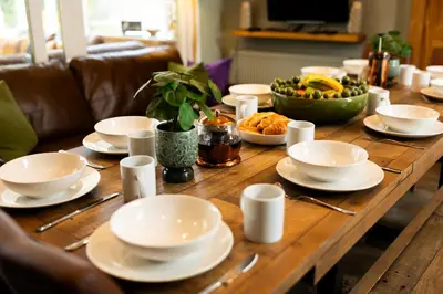 a wooden table with plates and bowls of food on it at Rhumhor House in Carrick