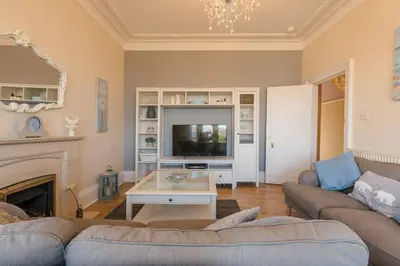 a living room with a couch and a tv at Arran View in Prestwick