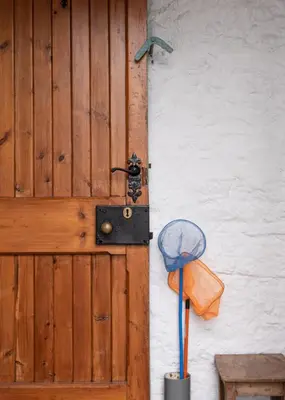 a wooden door with a hat and a mop at Coachmans Bothy - 50m from the beach in Port Appin