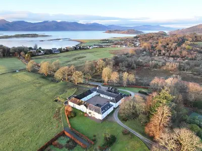 an aerial view of a house in a field at Coachmans Bothy - 50m from the beach in Port Appin