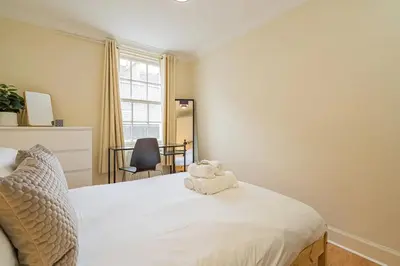 a bedroom with a bed with a stuffed animal on it at 2BR Grassmarket Apartment with Castle View in Edinburgh