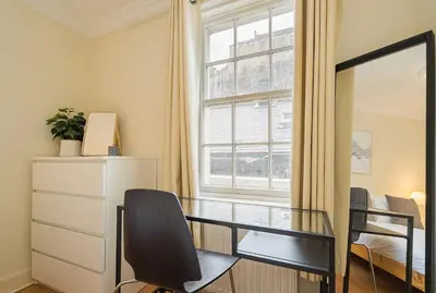 a desk and chair in a room with a window at 2BR Grassmarket Apartment with Castle View in Edinburgh