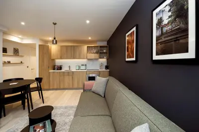 a living room and kitchen with a couch and a table at Wilde Aparthotels Edinburgh Grassmarket in Edinburgh