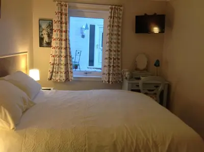 a bedroom with a white bed and a window at Saorsa House Culross in Fife