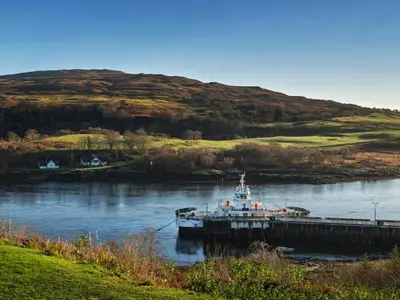 a boat docked at a dock in a river at Blue Watch in Lochaline