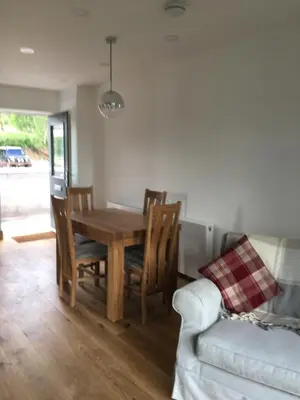 a dining room with a table and chairs and a couch at Blue Watch in Lochaline
