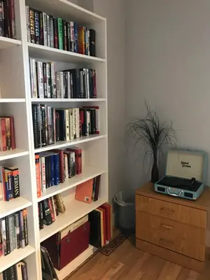 a book shelf filled with books and a laptop on a desk at The Neuk in Uphall