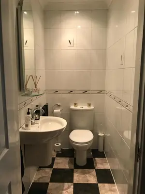 a white bathroom with a toilet and a sink at The Neuk in Uphall