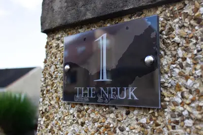 a sign for the nextk on a stone wall at The Neuk in Uphall