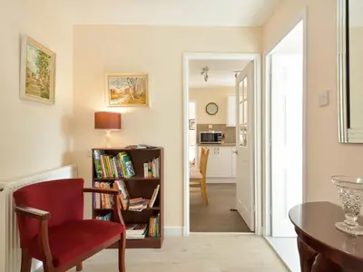 a living room with a red chair and a table at Westburn in Comrie